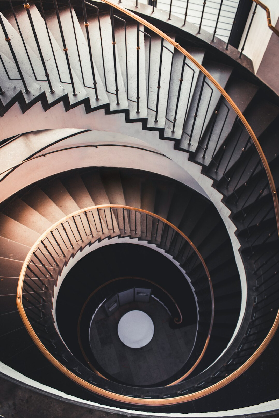 Spiral staircase in a minimalist architectural interior seen from above